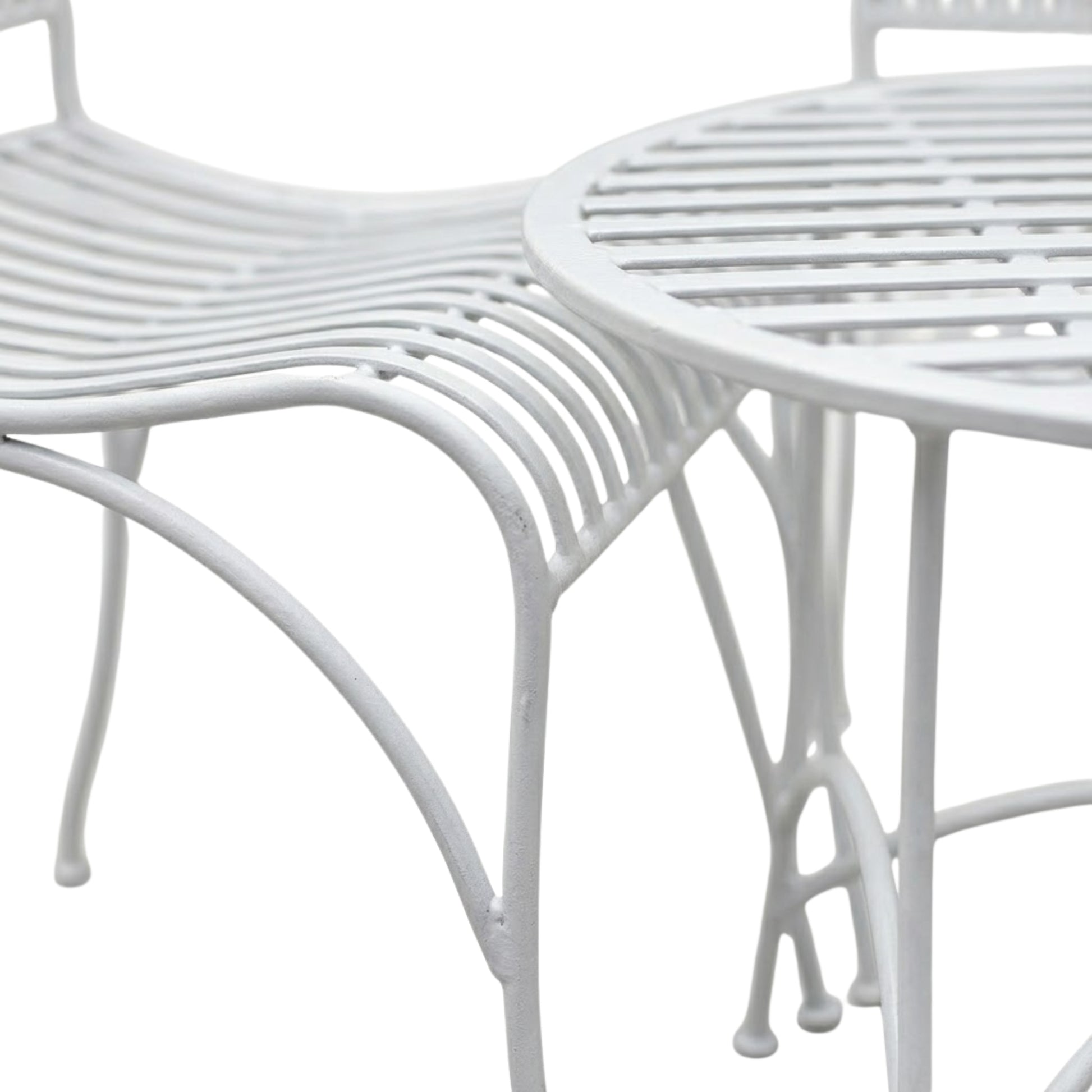 Close up detail of white metal bistro table curved legs and mesh tabletop design