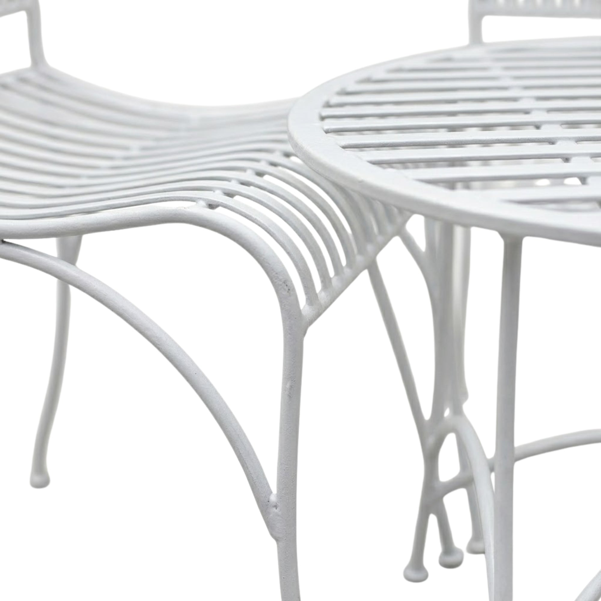 Close up detail of white metal bistro table curved legs and mesh tabletop design